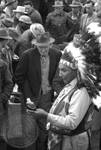 Native American man (Choctaw) in regalia sells medicine to crowd: Image 1 by Edwin E. Meek