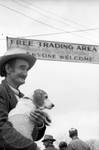 Man holding beagle under trade day sign: Image 2 by Edwin E. Meek
