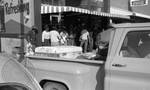 African Americans standing in line outside shop by Edwin E. Meek