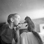 Young boy sharing apple with pet squirrel: Image 4 by Edwin E. Meek