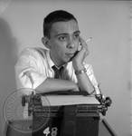 Paul Grey seated at typewriter: Image 1 by Edwin E. Meek