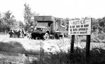 Military personnel at camp, standing around truck: Image 1 by Edwin E. Meek
