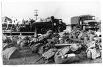 Military troops duffel bags piled in yard by Edwin E. Meek
