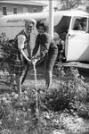 Women watering garden in front of University of Mississippi truck by Edwin E. Meek