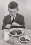 A school lunch - just right for a hungry boy. Michael Doyle gets ready to enjoy his meal - a tangy glass of orange juice, meat loaf with baked sweet potato and cabbage-carrot salad, enriched white bread with butter (or margarine), and milk to be topped off with a peanut butter cookie. by USDA