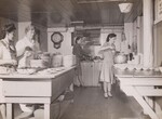 Kitchen, food preparation and service. Cook and assistant with volunteer workers ready for noonday food service. Massachusetts.