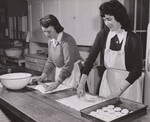 Catherine Farrell (left) and Ann Harmon, of the Damascus, Md., High School, roll out dough and cut biscuits for lunch. This consolidated country high school operates under the joint Federal-State program. by USDA