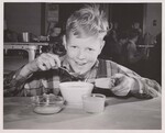 Boy eating his school lunch. by USDA