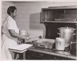 Forty pounds of utility grade meat are cooked at "Margaret Washington" each day for the reimbursable lunch program. Here's one of the two paid workers. The rest of the job of feeding 300 youngsters daily is done by Margaret Washington students studying cafeteria service. by USDA