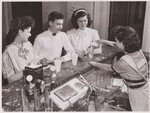 Milk drinks are served at the "milk bar" in the cafeteria at Hyattsville, Md., High School, and all chocolate drinks are mixed with whole milk. Here (left-right) Mildred Lipo, Bernard King and Dolores Holman are served by Florence Snyder, a student majoring in home economics. These majors take turns working in the kitchen and at the counters, and get credit for one hour of work per day. by USDA