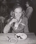 Eunice Schirner, 5th grade student, member of school's Girl Scout Troop, sips milk while enjoying her lunch in school cafeteria. Wenham Center School, Wenham, Mass.