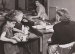 Billie Depuy (right) and George Reed check in their lunch trays with the cashier, Mrs. Margaret Browning, a volunteer mother working as a volunteer "checker," at East Silver Spring, Md., Elementary School. Mrs. Ruth McCeney, cafeteria manager (rear), serves the hot lunches. by USDA