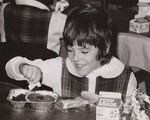 A student at St. Anthony de Padua parochial school puts ketchup on hamburger. The schools of this archdiocese that do not have kitchen facilities available are serving the students in flight type lunches. This program is part of USDA's Food and Nutrition Service School Lunch Program. Philadelphia, Pa. by USDA