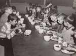 Students at the rural, three-room Bonner School here eat lunch January 1964, under the National School Lunch Program. Because of local, State and Federal efforts and U.S. Department of Agriculture foods, schools like Bonner in eastern Kentucky can now participate in the National School Lunch Program, and thousands of children in remote Kentucky schools are being served lunch ast school for the first time. Of the 58 children attending Bonner School, only 22 were able to pay 10 cents toward their lunch on the day this picture was taken. The rest were served free.  SCHOOL LUNCH United States Department of Agriculture Office of Information